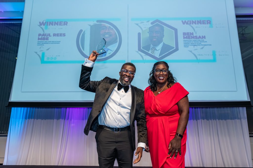 Award winner and presenter smiling on stage at the awards ceremony
